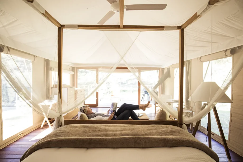 Luxury glamping in the blue mountains showing a woman reading in bed